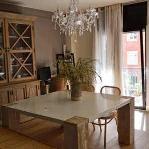 El comedor, con alacena de madera y lámpara de araña, da paso a la terraza. Tradición, elegancia y modernidad serena.