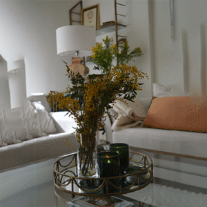 El salón, en tonos neutros y tejidos naturales, transmite serenidad. Las flores y las velas aportan calidez a una estancia que invita a quedarse.