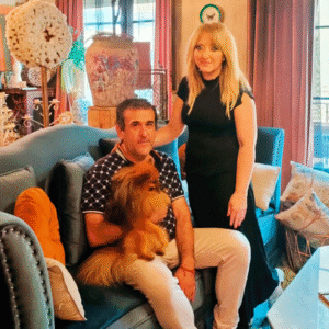 Ángel y Rosa, junto a su perro Leo, en el salón. Arte floral, papel pintado y personalidad desbordante.